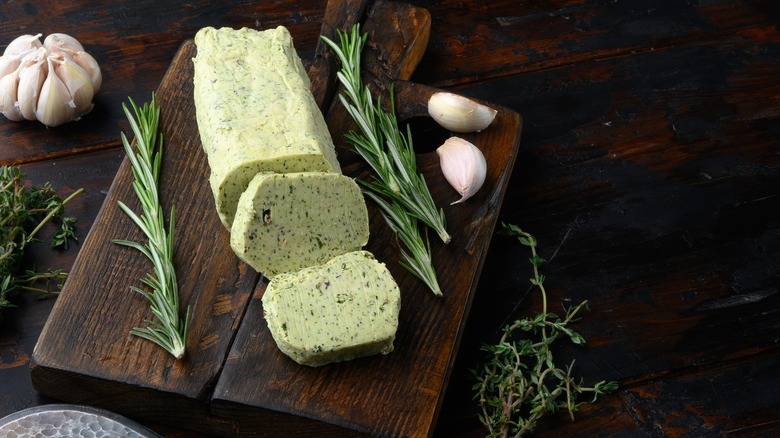 Garlic and herb compound butter on wood board