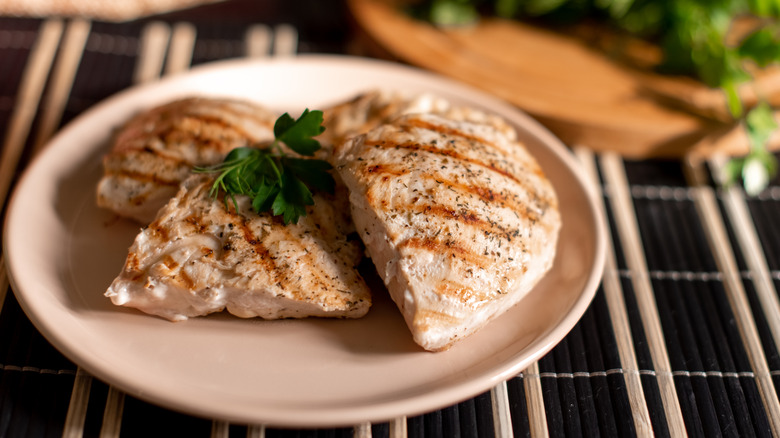 Seasoned grilled chicken breast served with herbs.