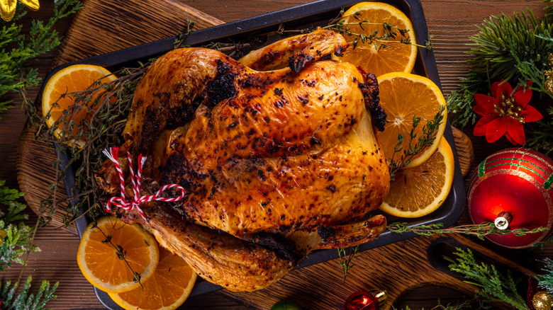 A whole roasted chicken with orange slices for holiday dinner.