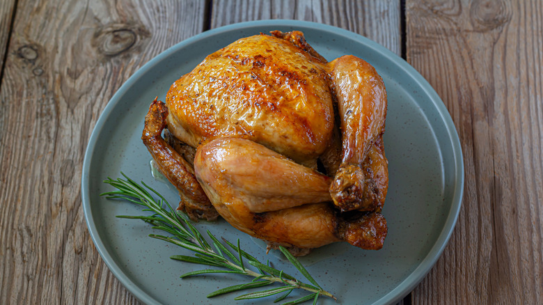 Roast chicken on platter with rosemary