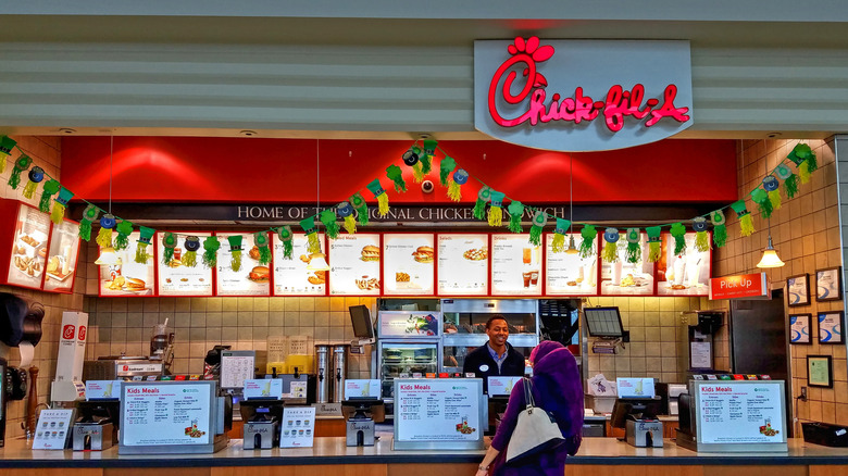 Chick-fil-A ordering counter with employee and customer.