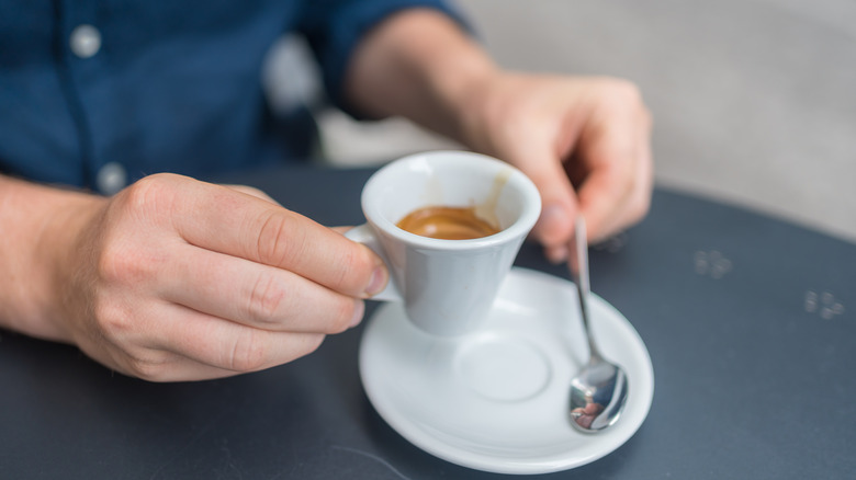 Man with espresso and spoon