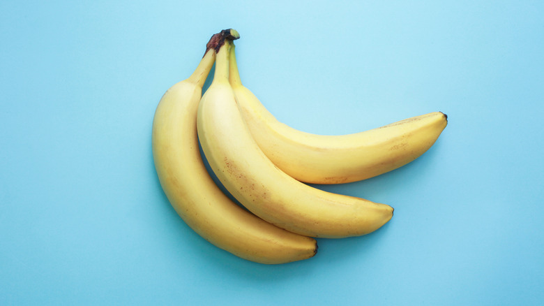 Ripe yellow bananas on blue background