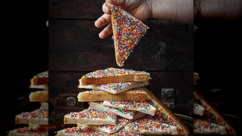 Stack of fairy bread halves with dark wooden background