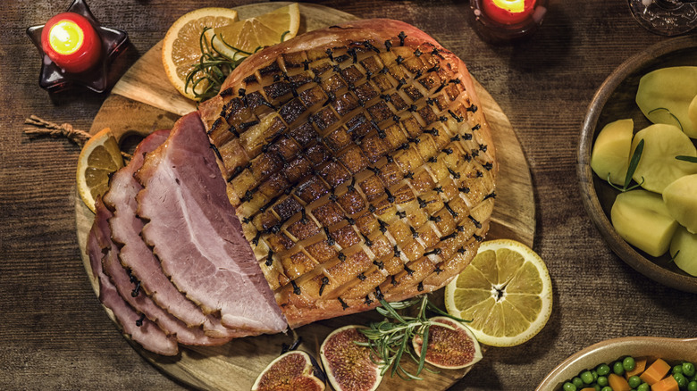 Top view of a glazed holiday ham on wood server.