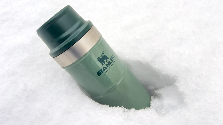 Stanley Action Trigger thermos mug standing in the snow.