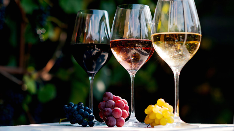 Three glasses of  colorful wine with grapes