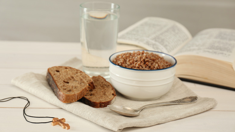 Bread, water, and grains with a holy cross and Bible