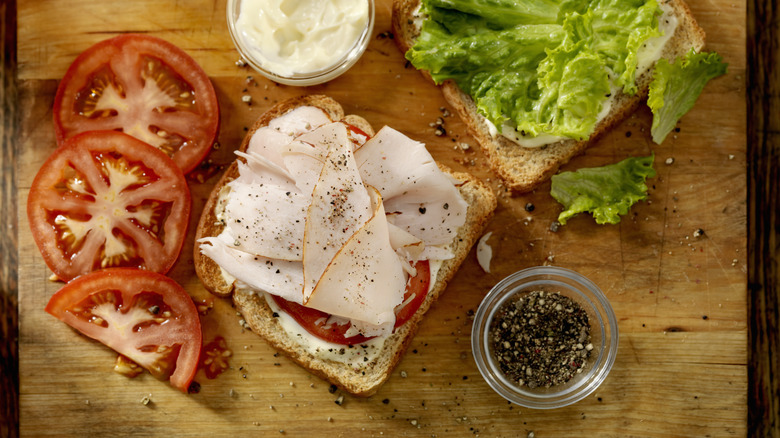 assembling sandwich on cutting board