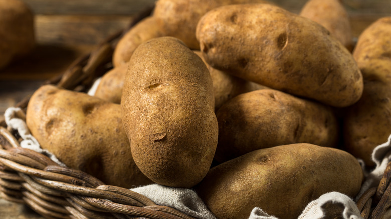 Golden brown russet potatoes in a woven basket