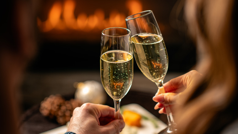 Two hands toast with flutes of sparkling wine