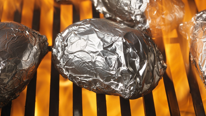 Potatoes in foil on flaming grill