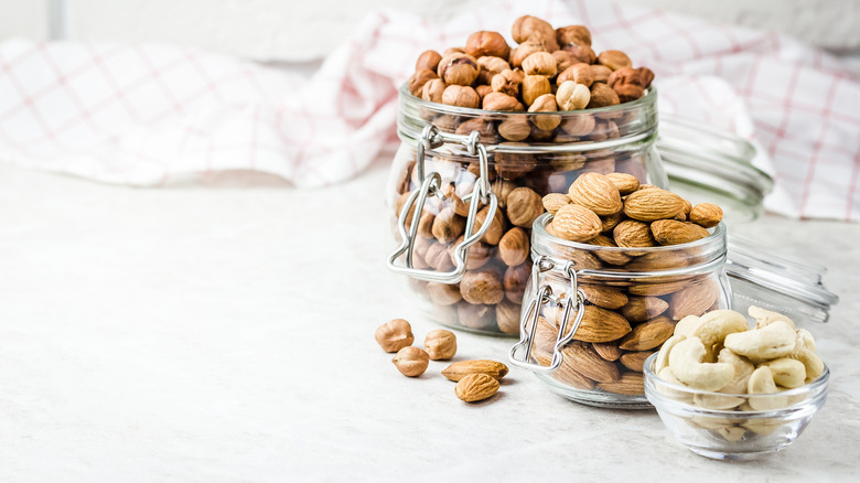 three jars overflowing with different types of nuts