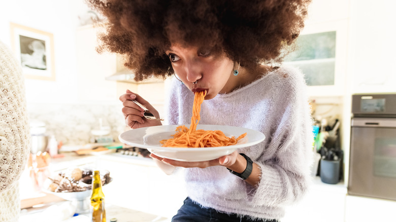 woman eating a bowl of pasta