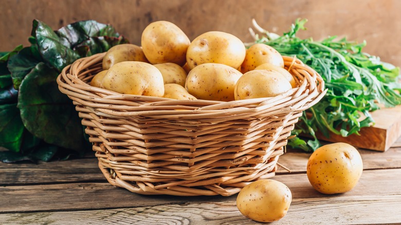 Potatoes in a basket on wooden table