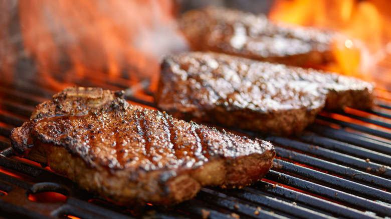 Steaks on a fiery grill.