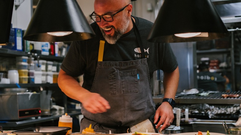 Chef Gilberto Cetina smiling while cooking