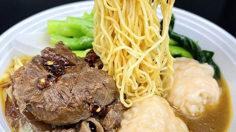 Beef and noodle dish in white bowl from Maxi's Noodle