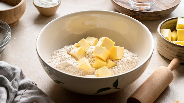 cubes of butter sitting in bowl of flour