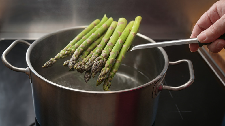 Asparagus being dropped into boiling water 