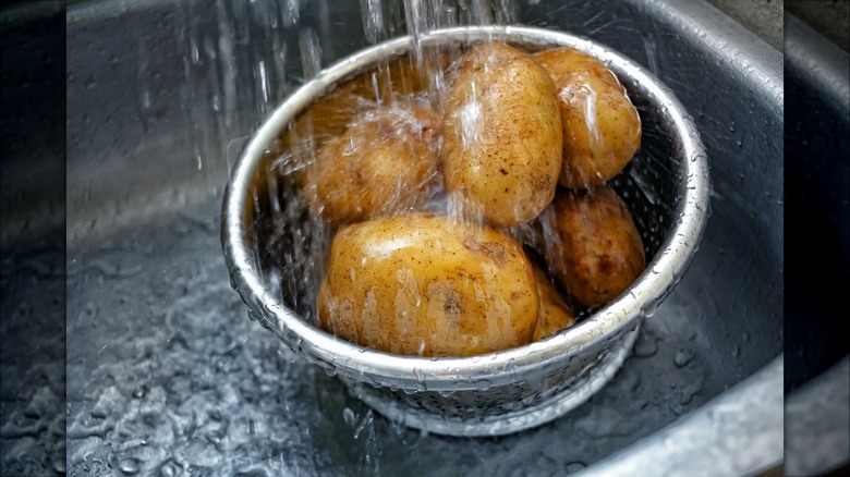 rinsing potatoes under water