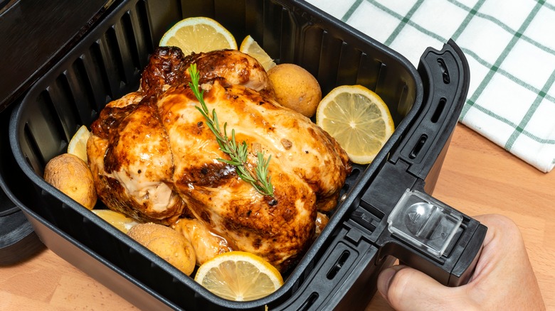 Chicken, lemon, potatoes, and herbs in air fryer